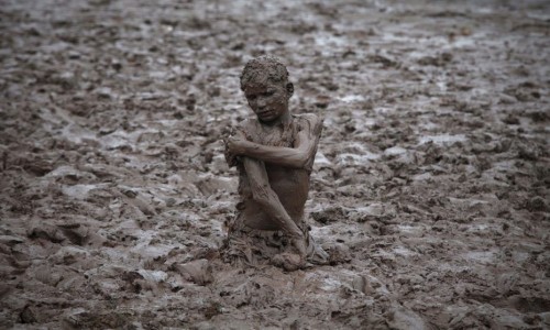 763367_a-boy-plays-in-the-mud-near-the-ravi-river-after-a-d.jpg