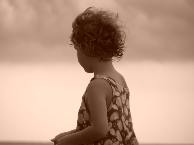 Une petite fille sur une plage de Corse.